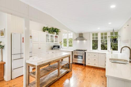 a kitchen with white cabinets and a wooden floor at Historic Charm & Elegance, Near Grammar! in Toowoomba