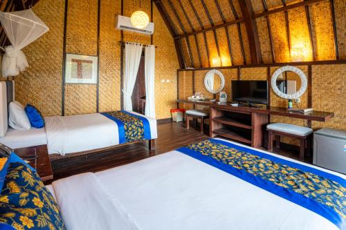 a hotel room with two beds and a television at Samawa Seaside Resort in Sumbawa Besar