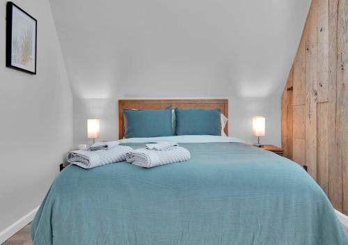 um quarto com uma cama azul com toalhas em 1BR Apartment near Ark Encounter with Parking em Dry Ridge