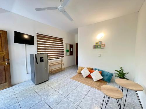 a living room with a refrigerator and two chairs at Hotel Nany in Brasilito