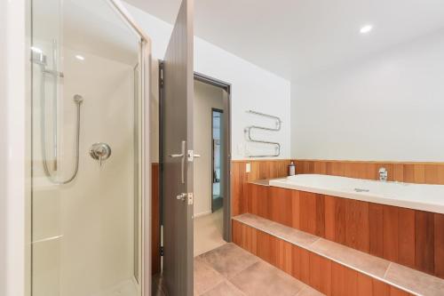 La salle de bains est pourvue d'une baignoire, d'une douche et d'un lavabo. dans l'établissement Tepuia Daze - Havelock Holiday Home, à Picton