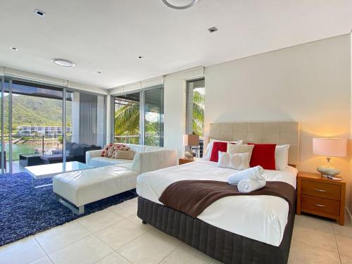 um quarto com uma cama grande e uma sala de estar em Blue on Blue Penthouse Apartment 335 em Nelly Bay