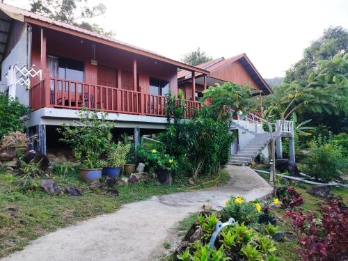 uma casa com varanda e algumas plantas em Restu Chalet Tioman em Ilha Tioman