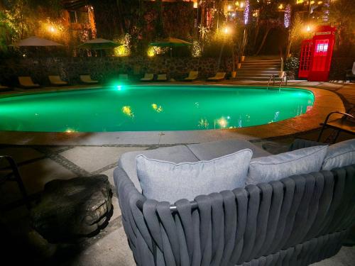 een zwembad 's nachts met een bank ervoor bij Hotel Grand Vista Cuernavaca in Cuernavaca