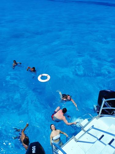 a group of people playing frisbee in the water at Catamaran Fragata Cancun in Cancún