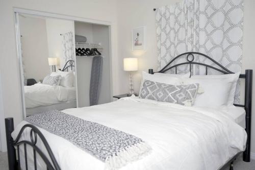 a bedroom with a white bed and a large mirror at LBC Cozy Suite -Downtown! Beach! in Long Beach