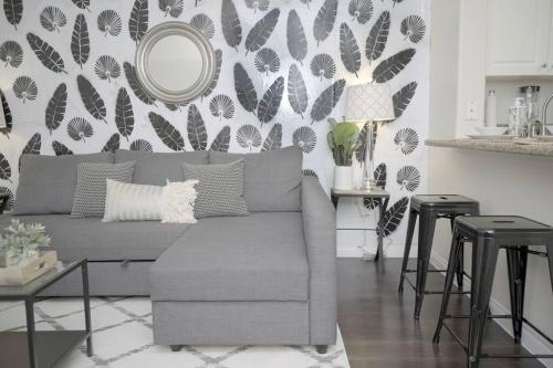 a living room with a gray couch and a mirror at LBC Cozy Suite -Downtown! Beach! in Long Beach
