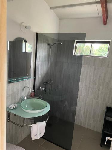 ein Badezimmer mit einem grünen Waschbecken und einer Dusche in der Unterkunft Residencia Piri in Piribebuy