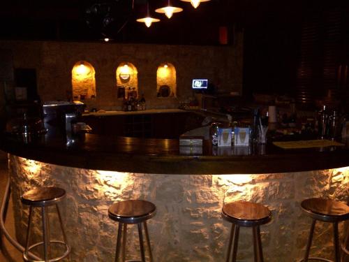 a bar with three bar stools in a room at Kallicrates Village in Frangokastello