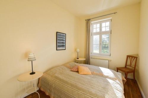 1 dormitorio con cama y ventana en Wohnung im ersten Obergeschoss des Gutshauses en Neuenkirchen