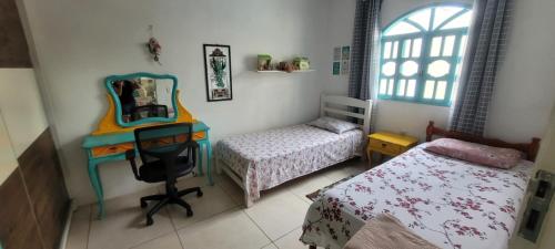 um quarto com uma secretária, uma cama e um espelho em Casa 3 quartos 2 banheiros patio gramado fechado com piscina em Guarapari