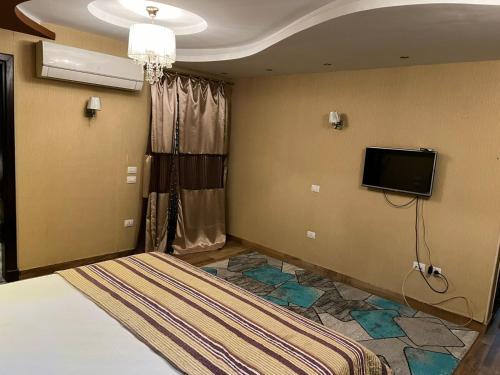 a bedroom with a bed and a flat screen tv at شقة فندقية على النيل مباشر بالمعادى ٣ غرف ٣ حمام in Cairo