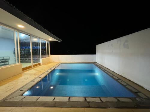 una piscina en una casa por la noche en MC Bunaken Inn & Dive en Bunaken