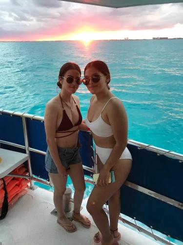 two women standing on a boat in the ocean at Catamaran Fragata Cancun in Cancún