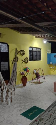Habitación con hamaca y pared amarilla. en Kátia Lucia en Lucena