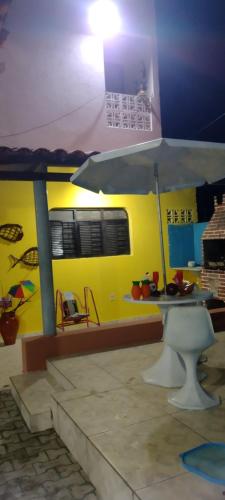 um quarto com uma mesa e uma parede amarela em Kátia Lucia em Lucena