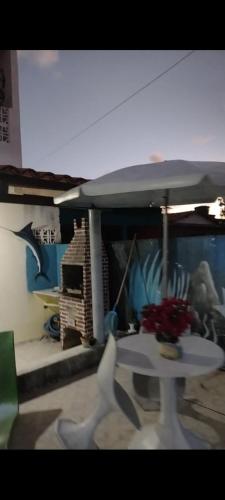 un tavolo bianco con ombrellone in una stanza di Kátia Lucia a Lucena