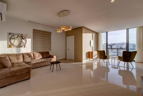a living room with a couch and a table and chairs at Stunning 3BED with views Mellieha by Homely in Mellieħa
