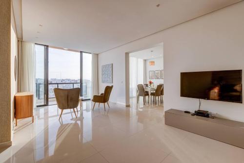 a living room with a television and a dining room at Stunning 3BED with views Mellieha by Homely in Mellieħa