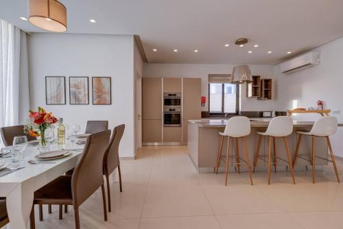 a kitchen and dining room with a table and chairs at Stunning 3BED with views Mellieha by Homely in Mellieħa