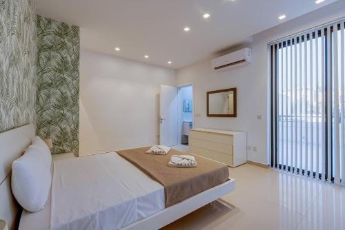 a bedroom with a large bed and a large window at Stunning 3BED with views Mellieha by Homely in Mellieħa