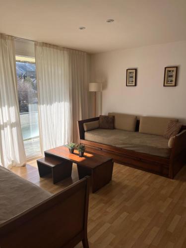 uma sala de estar com um sofá e uma mesa em Catedral Ski & Summer em San Carlos de Bariloche