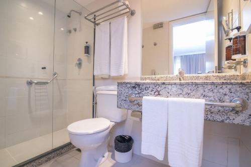 a bathroom with a toilet and a shower at Flat Barra First - Morada Stay in Rio de Janeiro