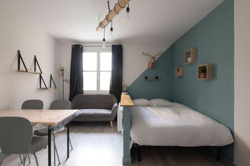 een slaapkamer met een bed, een tafel en een stoel bij Pretty ski nest in the city center in Gérardmer