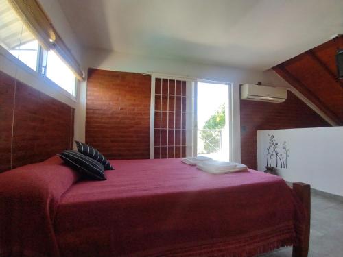 a bedroom with a large red bed with a window at Cabañas AK Tu Lugar in Potrero de los Funes