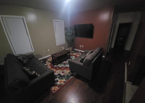 Sala de estar con 2 sofás y TV en Staycation Haven Room, en Newark