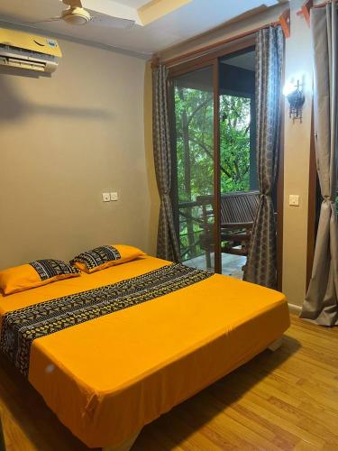 Cama amarilla en habitación con ventana en Zanzibar in Dar! A newly renovated 3br villa en Dar es Salaam
