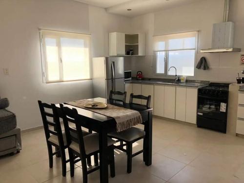 eine Küche mit einem Tisch und Stühlen im Zimmer in der Unterkunft Departamentos casa de mar in Playa Unión
