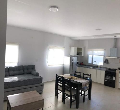 ein Wohnzimmer mit einem Sofa, einem Tisch und Stühlen in der Unterkunft Departamentos casa de mar in Playa Unión
