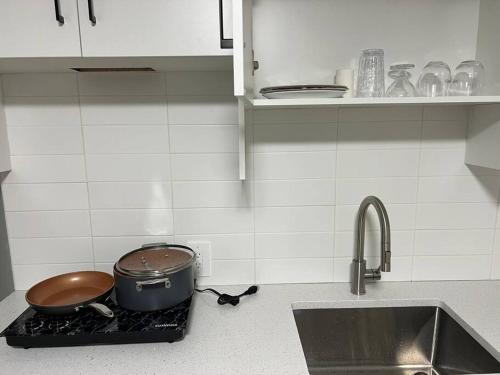 a kitchen with a sink and a pot on a stove at Not-Available - Do not book please in Airdrie