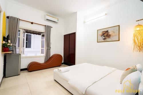 a white bedroom with a bed and a window at Mayhouse Vũng Tàu Hotel TPVT in Vung Tau