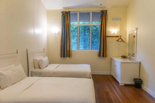a bedroom with two beds and a window at Sutera Sanctuary Lodges At Kinabalu Park in Kundasang