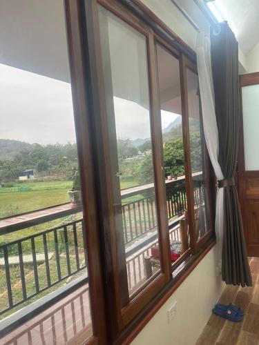 a room with a window with a view of a field at Peaceful MaiChau Homestay in Mai Chau