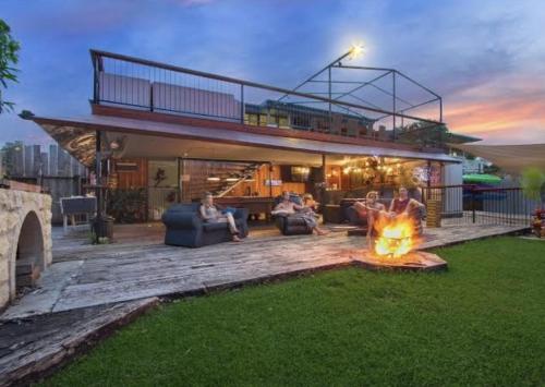 a group of people sitting around a fire in a backyard at Gladstone Backpackers in Gladstone