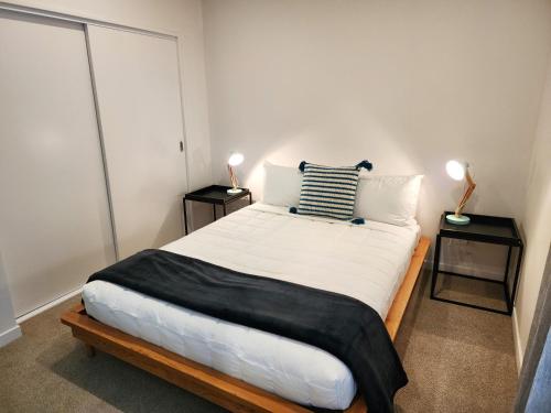 1 dormitorio con 1 cama grande y 2 mesitas de noche en U Suites on Victoria, en Wellington