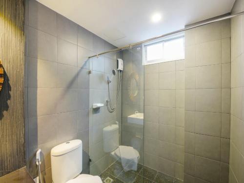 a bathroom with a toilet and a glass shower at Kitzio House Hotel Huai Kwang in Ban Na Song