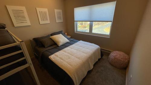a small bedroom with a bed and a window at Poconos Modern Chalet-Hot Tub-Home Theater-Lake in East Stroudsburg