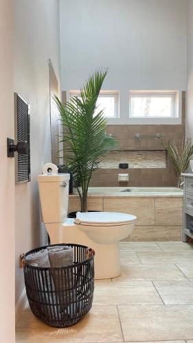 a bathroom with a toilet and a plant in it at Poconos Modern Chalet-Hot Tub-Home Theater-Lake in East Stroudsburg