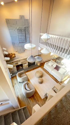 a living room with white furniture and a staircase at Poconos Modern Chalet-Hot Tub-Home Theater-Lake in East Stroudsburg