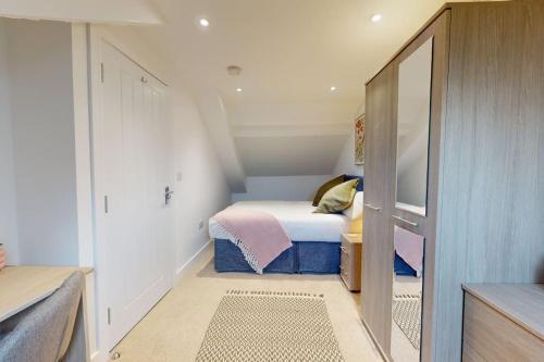 Habitación pequeña con cama y espejo. en Stylish and Modern 3 Bed Home - 5*, en South Shields