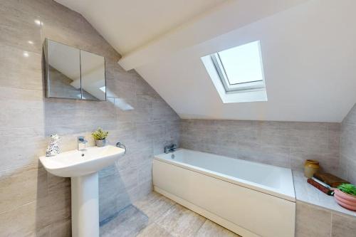 y baño con lavabo, bañera y espejo. en Stylish and Modern 3 Bed Home - 5*, en South Shields