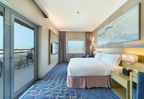 a hotel room with a bed and a balcony at Dar Rayhaan by Rotana Al Khobar in Al Khobar