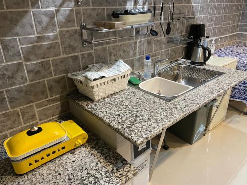 a kitchen counter with a sink and a yellow container at Elegance Kukou Minami B - Vacation STAY 12934 in Miyazaki