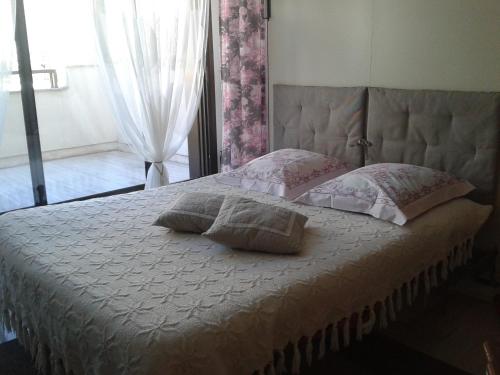 1 dormitorio con cama con almohadas y ventana en Gray d' Albion Apartment, en Cannes