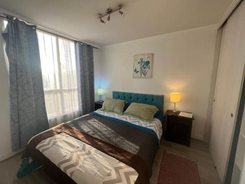 1 dormitorio con 1 cama con cabecero azul y ventana en Apartment Relocation 1 Dormitorio, en Santiago