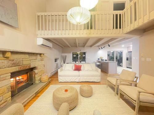 sala de estar con sofá blanco y chimenea en Poconos Modern Chalet - Home Theater - Hot Tub en East Stroudsburg